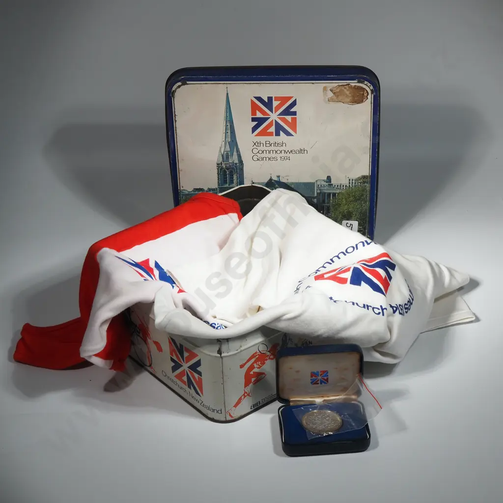 Commonwealth Games Tin Containing Tee Shirts, Cased One Dollar Coin Commemorating The 1974 Games Image 1++