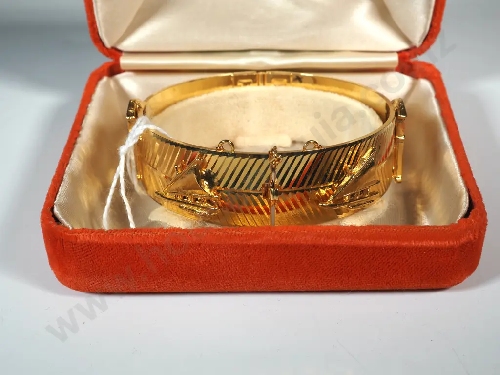 Cased Gold Coloured Snap Bangle w House/Sailboat Motif. Image 1++